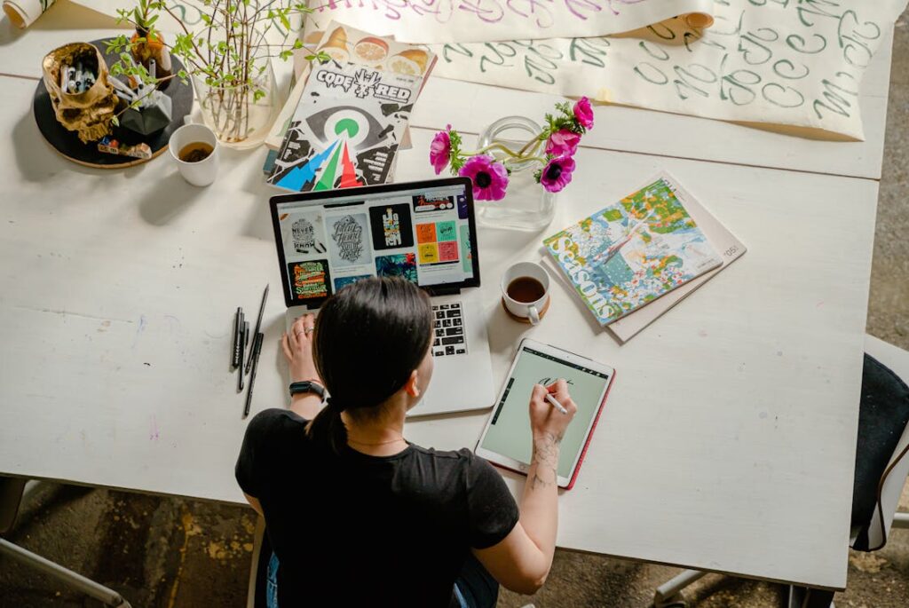 Mujer diseñadora gráfica sentada en un escritorio, dibujando en una tablet electronica