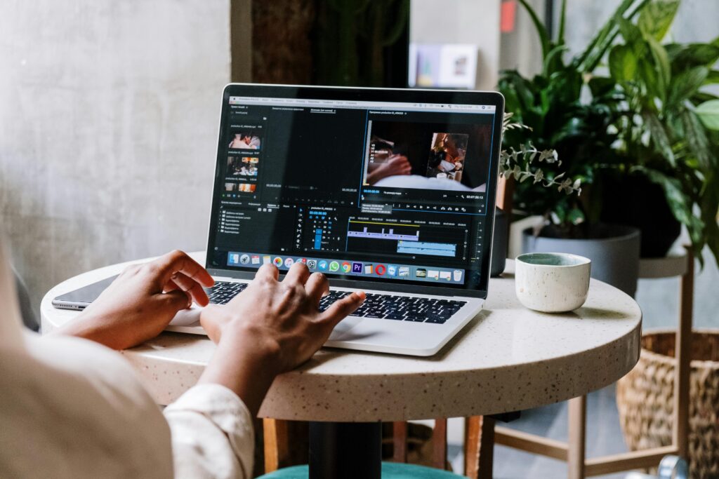 Una persona editando un video en una laptop con el software de adobe premiere.